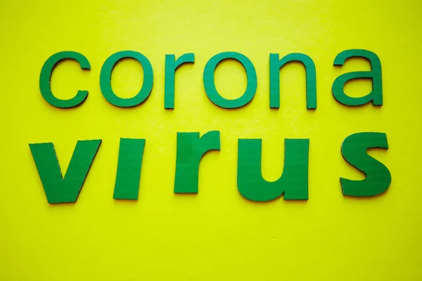 Parola CORONAVIRUS fatta di lettere di cartone verde, isolata su sfondo giallo. Organizzazione Mondiale della Sanità OMS ha introdotto un nuovo nome ufficiale per la malattia di Coronavirus denominato COVID-19 — Foto Stock