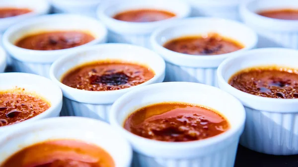 Rows of Creme brulee. Traditional French vanilla cream dessert with caramelised sugar on top. Shallow dof — Stock Photo, Image