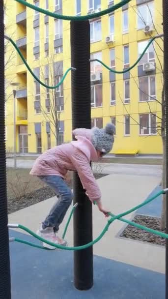 Meisje speelt op de touwenpark speelplaats. Het concept van kinderen rust in een stedelijke omgeving. — Stockvideo