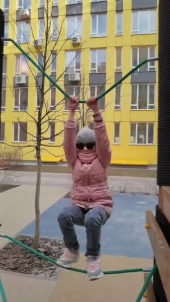 Chica juega en el parque de cuerdas. El concepto de descanso infantil en un entorno urbano. — Vídeo de stock