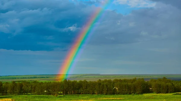 Duha nad venkovskou krajinou po bouřce. — Stock fotografie