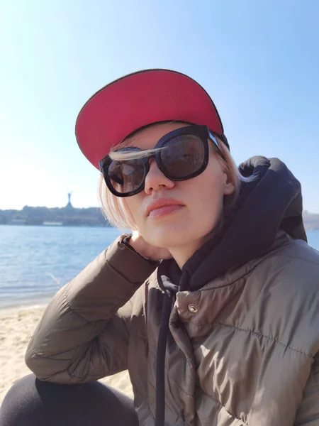 Giovane donna indossa occhiali da sole alla moda vicino al fiume — Foto Stock