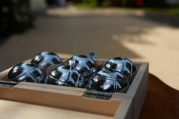 Шесть металлических петанковых шариков в деревянной коробке, готовых к игре — стоковое фото