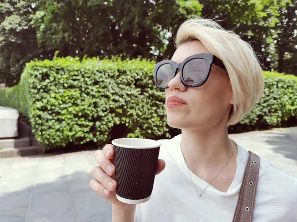 Attractive adorable woman with natural makeup sips of coffee in early morning on sunrise or sunset from to go cup — Stock Photo, Image