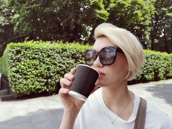 Jovem mulher elegante beber café para ir em uma rua da cidade — Fotografia de Stock
