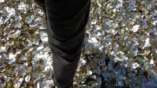 Kvinde går i konfetti på gulvet. – Stock-video