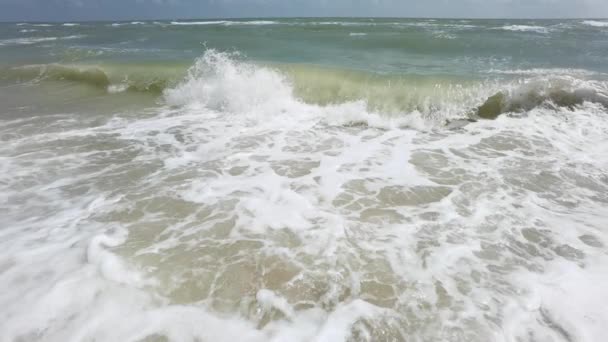 強力な海の波が海岸に墜落した。ビーチに飛び散る極端な嵐の海の波 — ストック動画