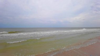 Köpüklü büyük gelgit dalgaları sahili yavaş çekimde eziyor..