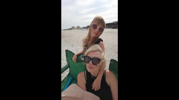 Портрет влюбленной матери и маленькой девочки, крепко обнимающейся на пляже на закате замедленной съемки — стоковое видео