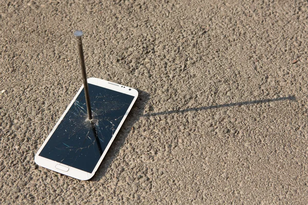 Composition of metal nail and smartphone — Stock Photo, Image