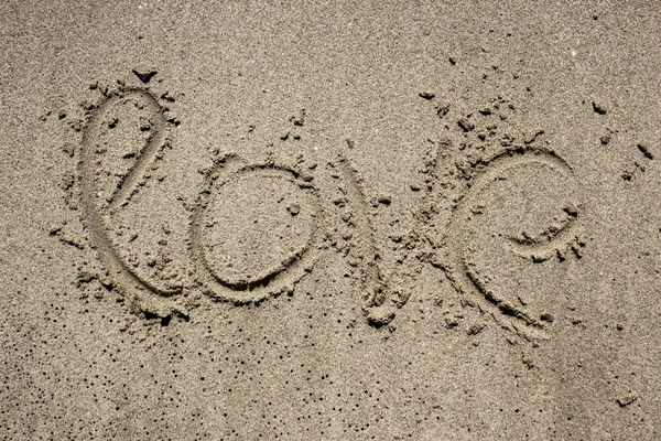 Inschrift auf Sand in Meeresnähe und Wellen. Liebe — Stockfoto