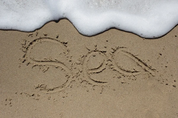 Wortstrand auf Sand geschrieben, die Welle kommt — Stockfoto