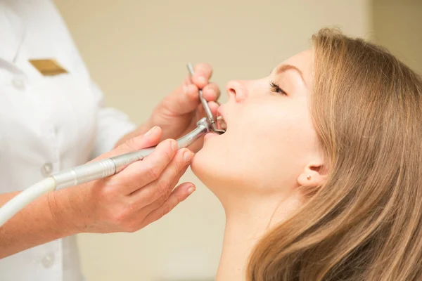 Dentista cura uma paciente do sexo feminino — Fotografia de Stock