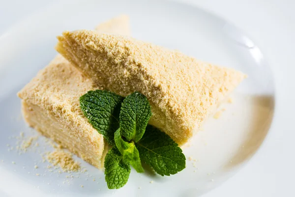 Tårta napoleon av smördeg med gräddfil på en tallrik. — Stockfoto