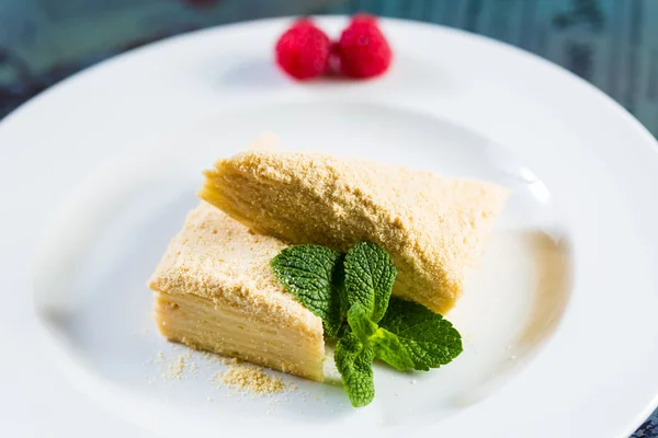 Tårta napoleon av smördeg med gräddfil på en tallrik. — Stockfoto