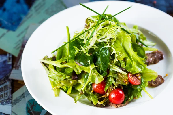 Salade de légumes frais avec viande et tomates cerises sur assiette blanche . — Photo