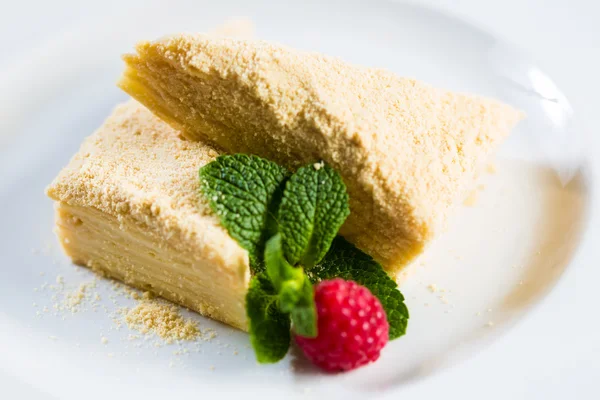 Pastel Napoleón de hojaldre con crema agria en un plato . — Foto de Stock