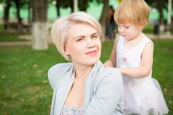 Portrait of beautiful mother and kid girl outdoors in park — Stock Photo, Image