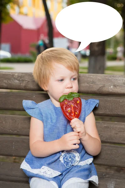 Beautiful little girl holding strawberry shaped lollipop — Stock Photo, Image