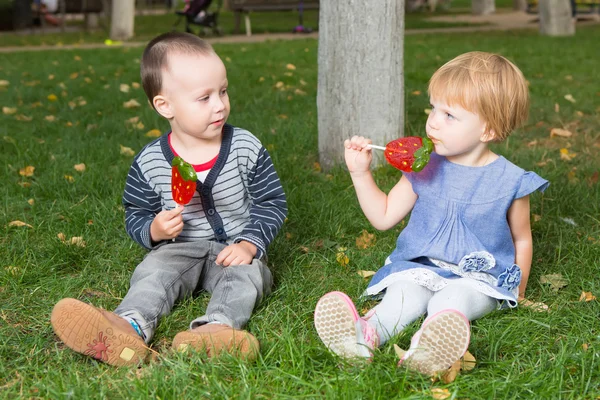 Adorable little kids with colorful lollipops — Stock Photo, Image