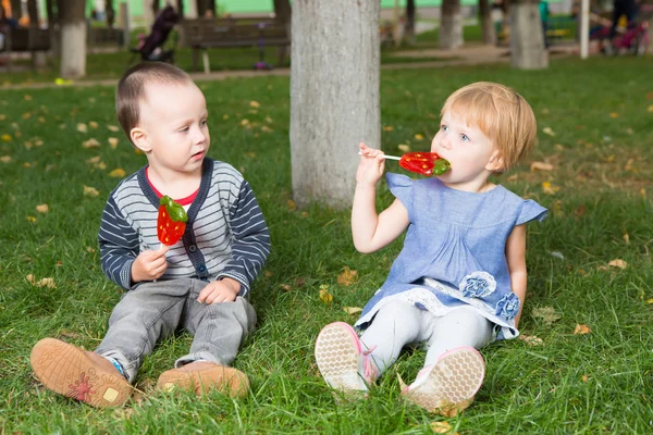 Entzückende kleine Kinder mit bunten Lutschern — Stockfoto