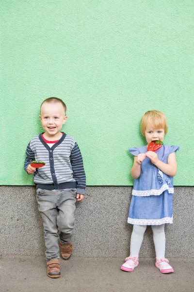 Entzückende kleine Kinder mit bunten Lutschern — Stockfoto