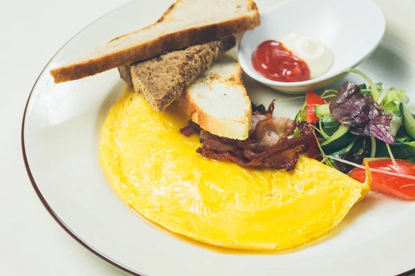 Omelete com bacon servido em prato branco, legumes de lado — Fotografia de Stock