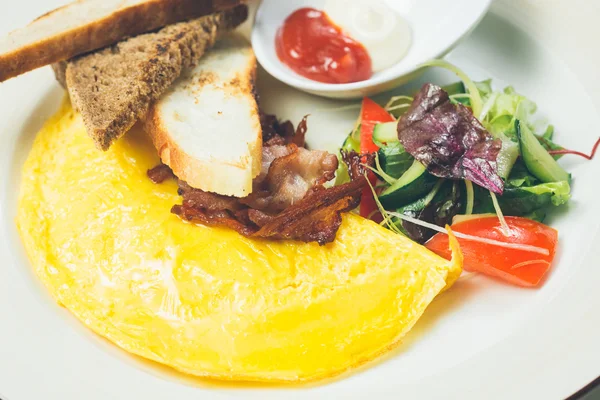 Omelette au bacon servi sur assiette blanche, légumes de côté — Photo