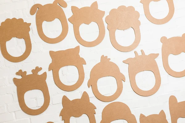Conjunto de máscaras de cartón en una pared de ladrillo blanco . — Foto de Stock