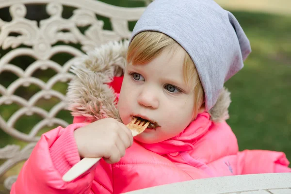 Kind isst Waffeln mit Schokolade im Park — Stockfoto