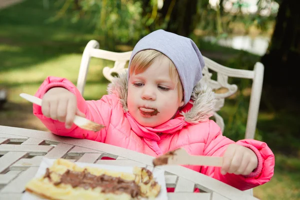 Child eating waffles with chocolate — Stock Photo, Image
