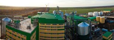 Towers of grain drying enterprise at sunny day clipart