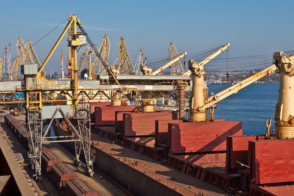 Grain from silos being loaded onto cargo ship on conveyor belt — Stock Photo, Image