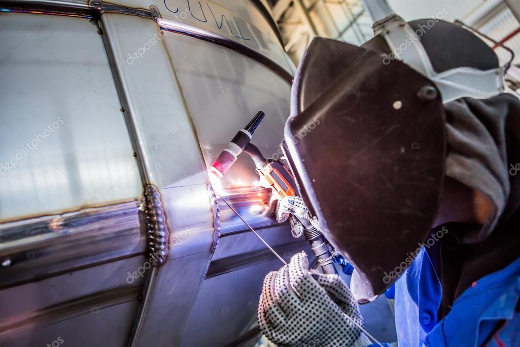 Man welding with reflection of sparks on visor. Hard job. — Stock Photo