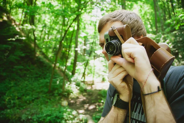 Closeup of young hipster man with digital camera outdoors. — Stock Photo, Image