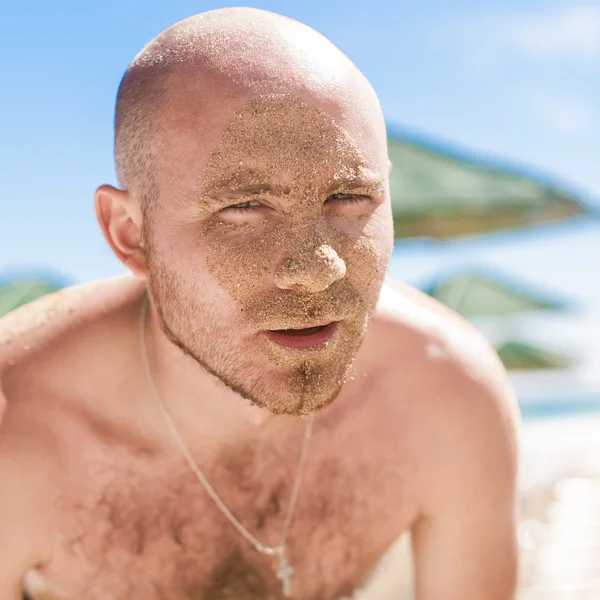 Metade da cara de um homem bonito coberto de areia — Fotografia de Stock