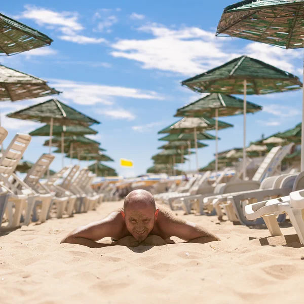 Metade da cara de um homem bonito coberto de areia — Fotografia de Stock