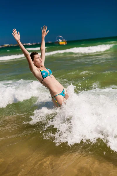 Femme éclaboussant l'eau dans l'océan — Photo