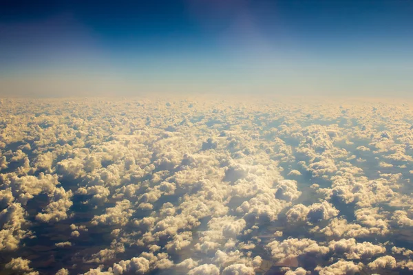 Λευκά σύννεφα στον καταγάλανο ουρανό. Αεροφωτογραφία από αεροπλάνο. — Φωτογραφία Αρχείου