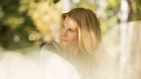 Portret van een mooie jonge vrouw in het park. — Stockfoto