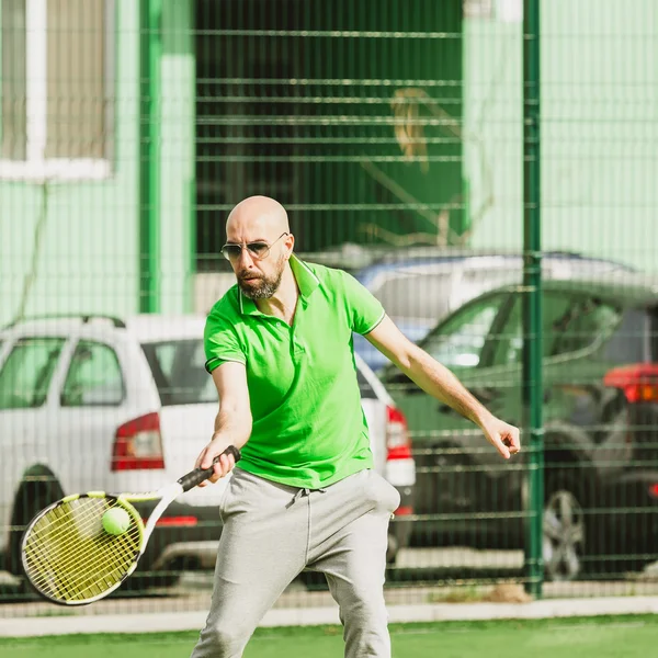 Человек играет в теннис на открытом воздухе — стоковое фото