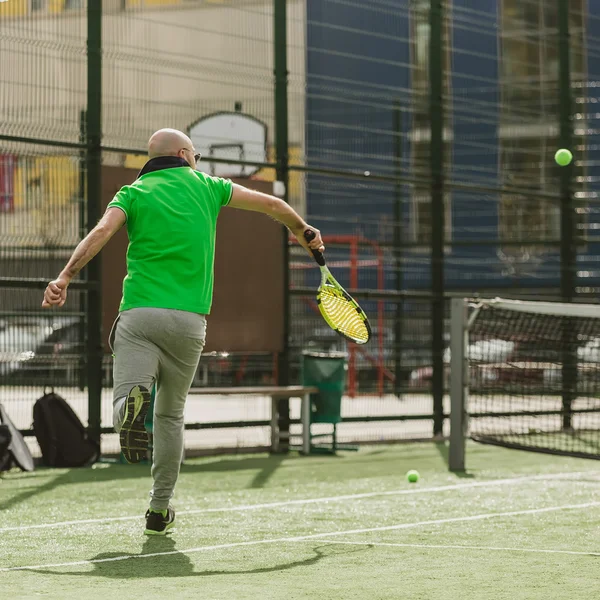 Человек играет в теннис на открытом воздухе — стоковое фото