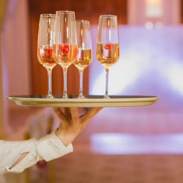 Garçom servindo champanhe em uma bandeja — Fotografia de Stock