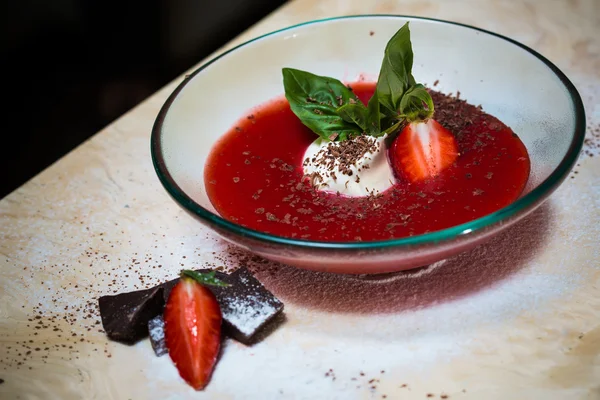 Клубничный суп с мороженым и мятой на тарелке украшен свежей клубникой — стоковое фото