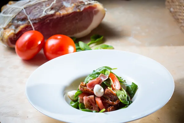 Salat mit Erdbeere, Prosciutto, Kräutern, Quark und Brombeeressig. — Stockfoto