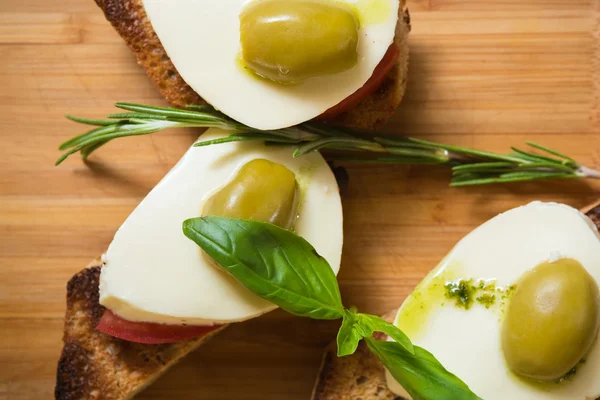 Bruschetta con pomodoro, mozarella e olive — Foto Stock
