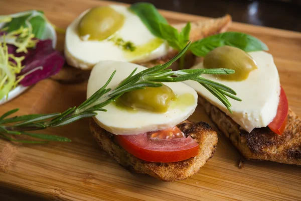 Bruschetta con pomodoro, mozarella e olive — Foto Stock
