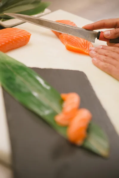 Резать лосося ножом — стоковое фото