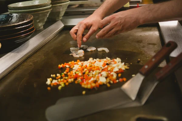 Шеф-повар варит рис с овощами и креветками — стоковое фото