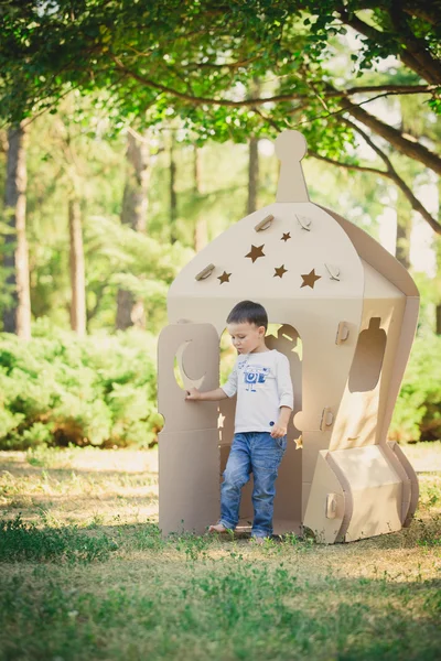 Bambino che gioca su un'astronave di cartone. Ecoconcetto — Foto Stock